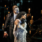 The Phantom holds Christine across the shoulders