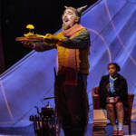 Mr Tumnus holds a book with a yellow flower growing. The Lion, The Witch and The Wardrobe West End Production photograph.