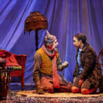 Mr Tumnus and Lucy sit and talk. The Lion, The Witch and The Wardrobe West End Production photograph.