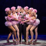 Bobby Childs stands surrounded by the Zeigler Follies in pink outfits