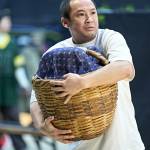 Steven Nguyen holding a basket with a blanket in it in front of him.